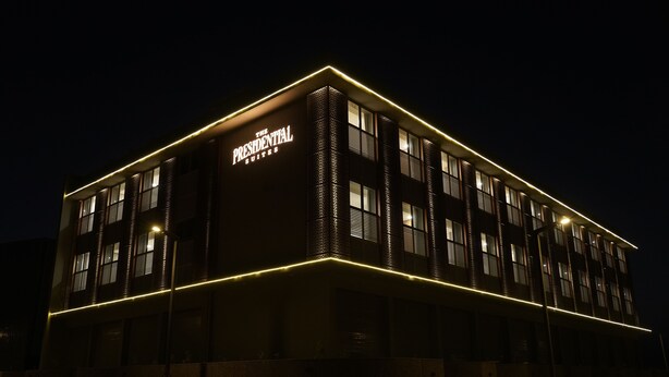 A building with a sign reading "The Presidential Suites" at night. - The Presidential Suites (Bhuj)
