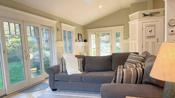 A living room with a grey sofa, striped rug, and a lamp. - The Pet-Friendly Surf Shack Hideaway on the Cove (Eastham)