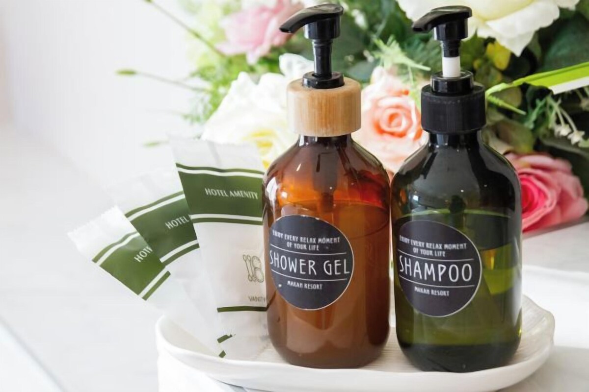 Two bottles of shower gel and shampoo on a tray with hotel amenities.