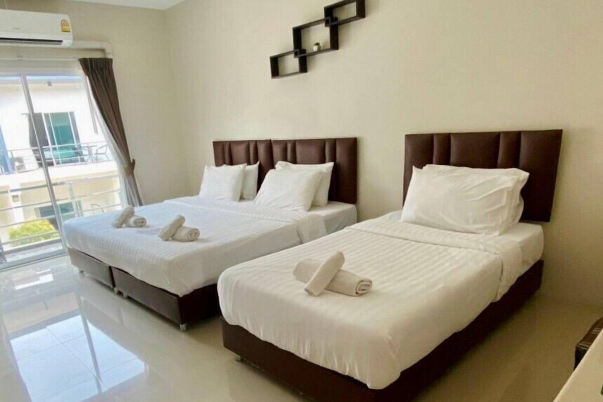 A hotel room with two beds, a large window, and a balcony.