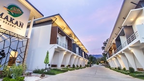 A modern hotel with a geometric facade, a prominent logo, and a well-lit entrance.