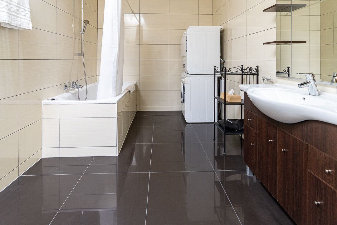 A modern bathroom with a bathtub, a sink, and a mirror.