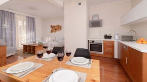 A modern apartment with a dining area, kitchen, and living space. - Stylish Apartment in Zakopane | Balcony | Close to Krupówki Street (Zakopane)