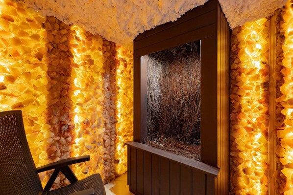 Un espacio de spa con pared de piedra y un cuadro enmarcado de un paisaje natural.