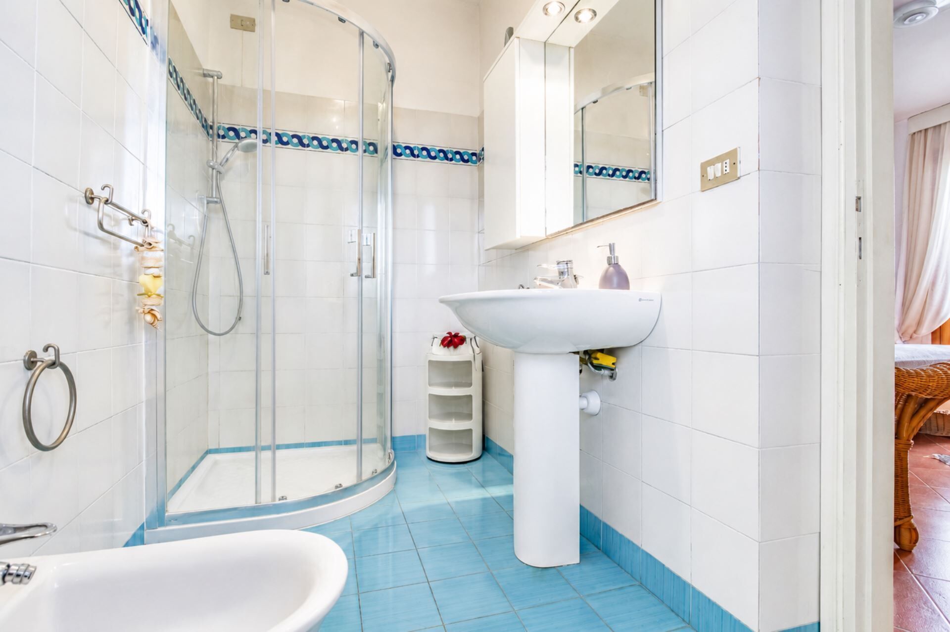 A bathroom with a glass shower enclosure, a white sink, and a bathtub.