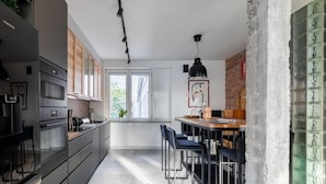 Una cocina moderna con comedor, que cuenta con un ventanal grande, una lámpara colgante y vistas al exterior.