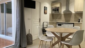 A modern kitchen with a microwave, stove, and dishwasher. There is a dining area with a table and chairs. - Vacation cottage with swimming pool in Saint-Rémy-de-Provence (Saint-Rémy-de-Provence)