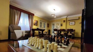 Un salon avec un jeu d’échecs, un canapé et une table à manger.