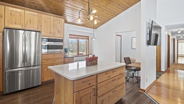 A modern kitchen with wooden cabinets, stainless steel appliances, and a central island. - Private Canandaigua Retreat- Hot Tub/Pet Friendly (Canandaigua)