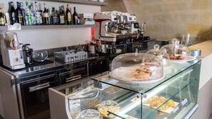 Un comptoir de boulangerie avec des pâtisseries et une machine à café.