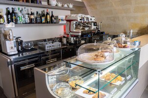 Un banco di pasticceria con dolci e una macchina per il caffè.