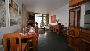 A modern kitchen and dining area with wooden furniture, a stone fireplace, and large windows. - Luxury chalet with best skiing in the South American Andes (farellones)