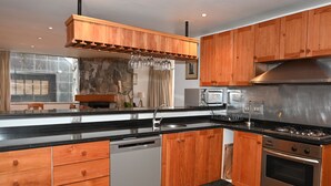 A modern kitchen with wooden cabinets, stainless steel appliances, and a built-in dishwasher.
