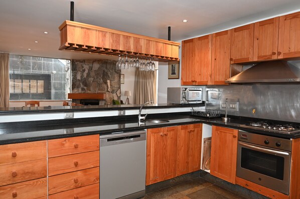 Una cocina moderna con armarios de madera, electrodomésticos de acero inoxidable y lavavajillas integrado.