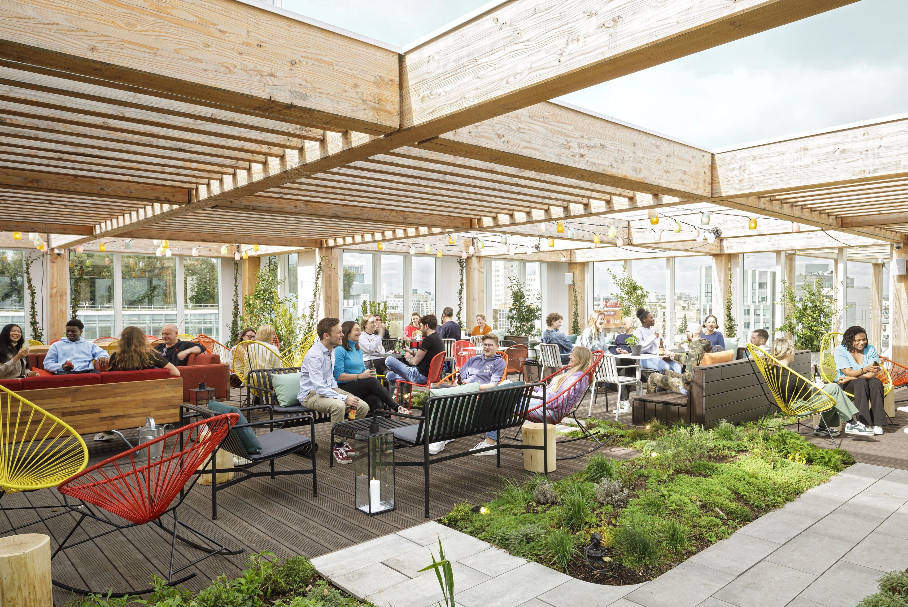An outdoor seating area with wooden beams, modern chairs, and a garden.