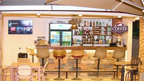 A bar area with a counter, stools, and a refrigerator. - Hotel Amaranth (Dar es Salaam)