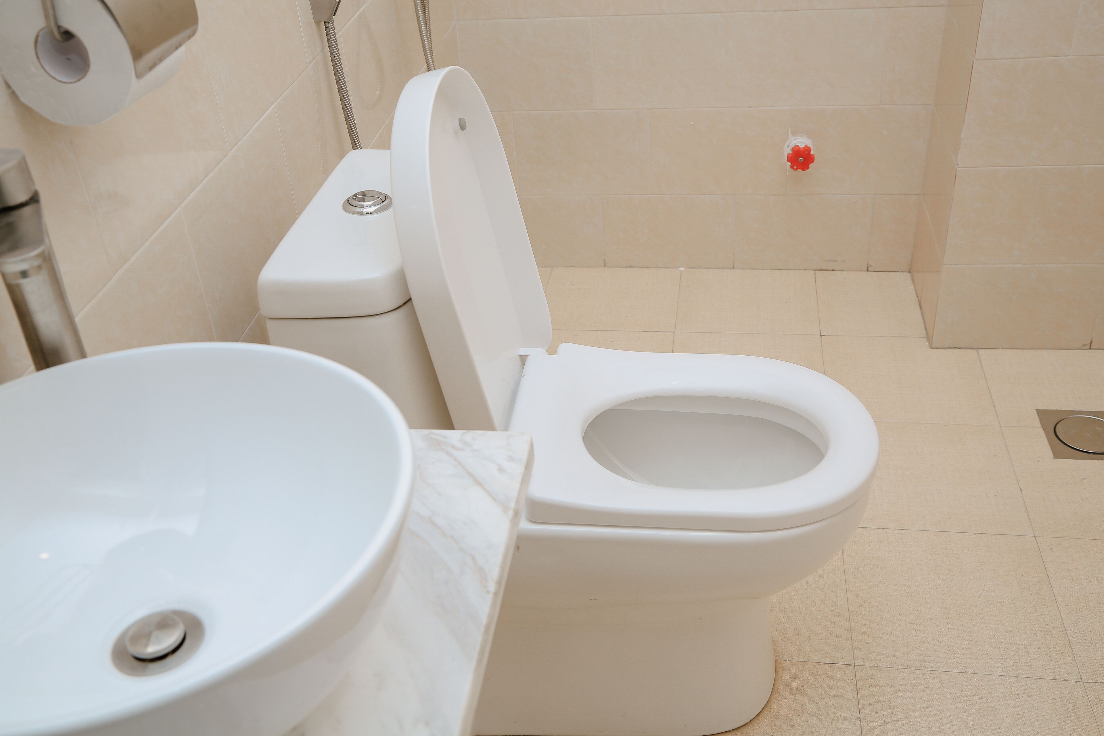 Et badeværelse med toilet, vask og brusebad.