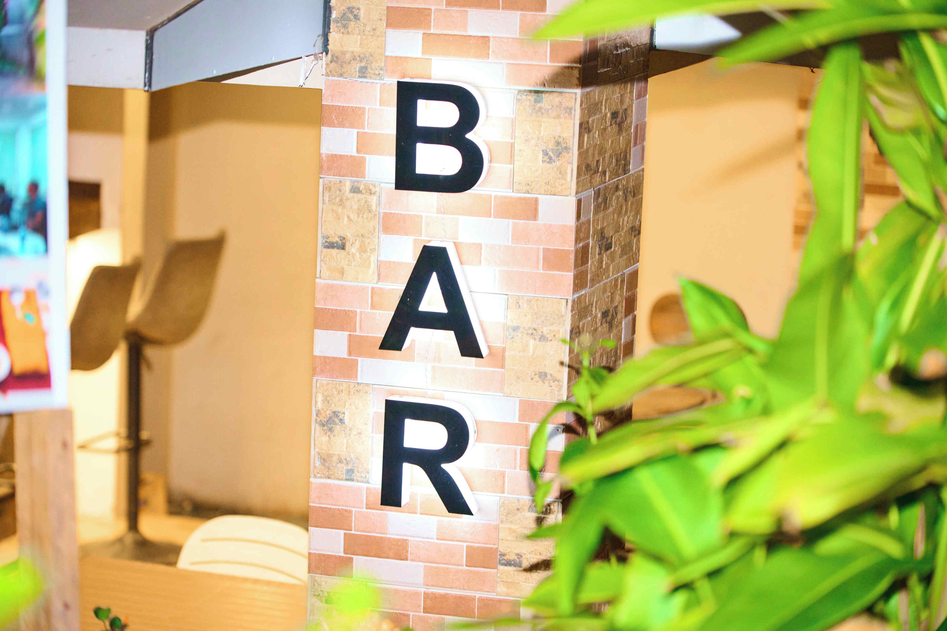 Pared con las letras "BAR" en grande y negrita, indicando una zona de bar.