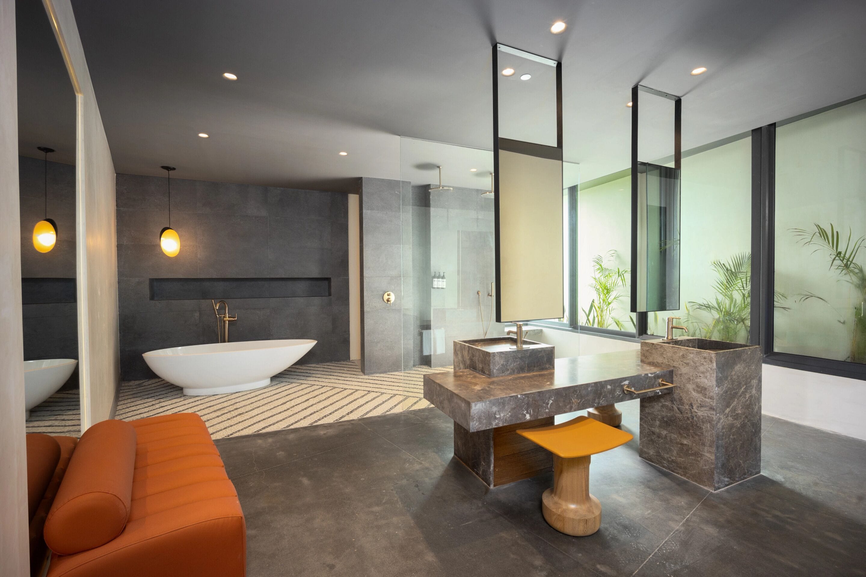 Une salle de bain moderne avec une baignoire sur pieds, un grand miroir et un banc en bois.