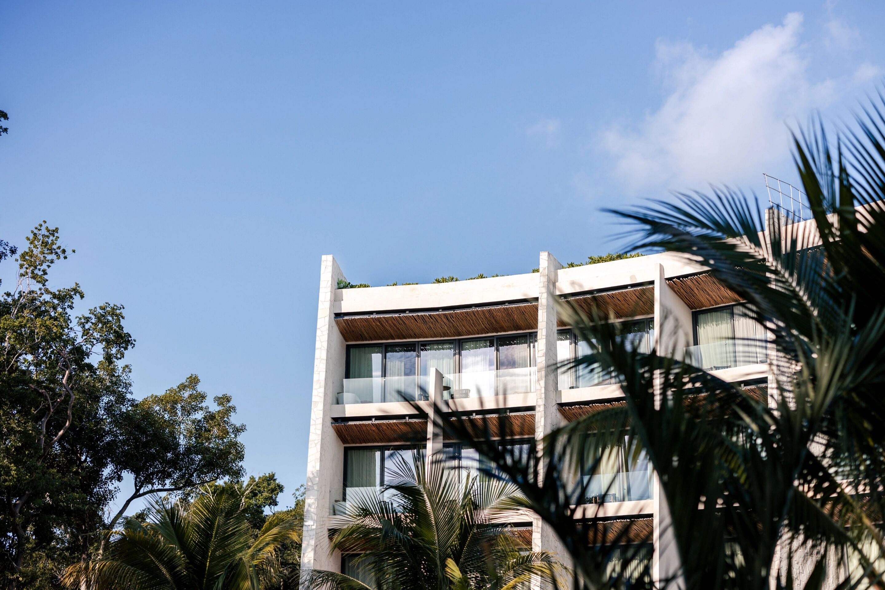 Un edificio moderno con varios pisos, ventanas amplias y balcones.