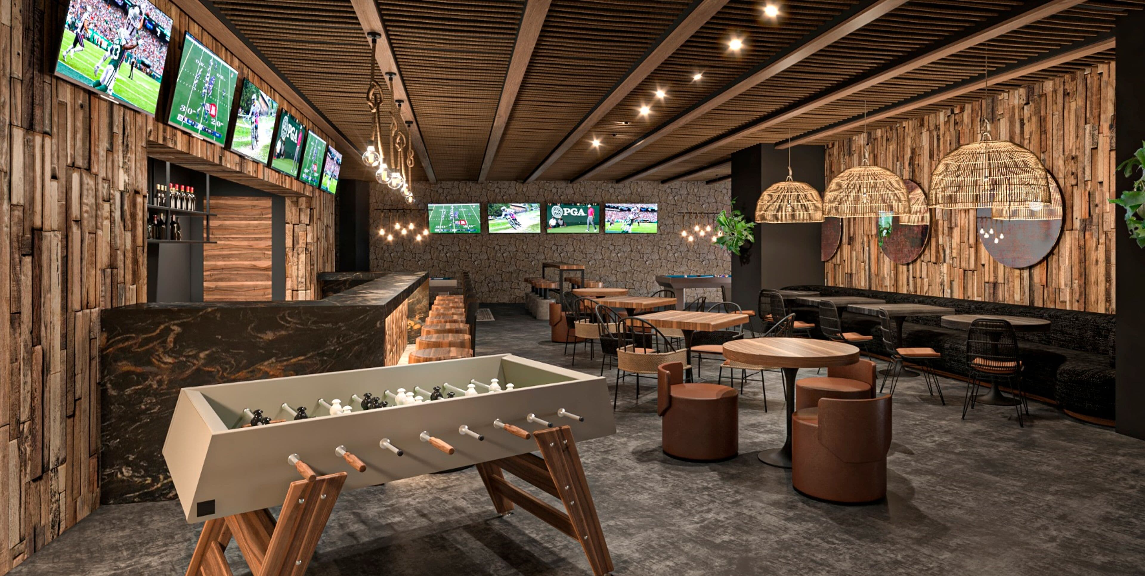 A modern bar area with multiple screens displaying sports events, a foosball table, and a variety of seating options including round tables and cushioned chairs.