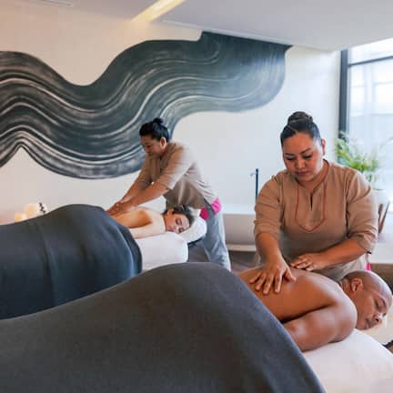 A massage therapy room with two clients receiving treatment.