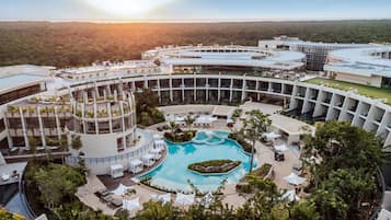 Relax by the resort's circular pool surrounded by lush greenery and outdoor seating areas.