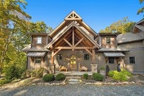 A two-story house with a prominent gable roof and a stone foundation.
