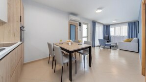 Un apartamento moderno con comedor, sala de estar y kitchenette.