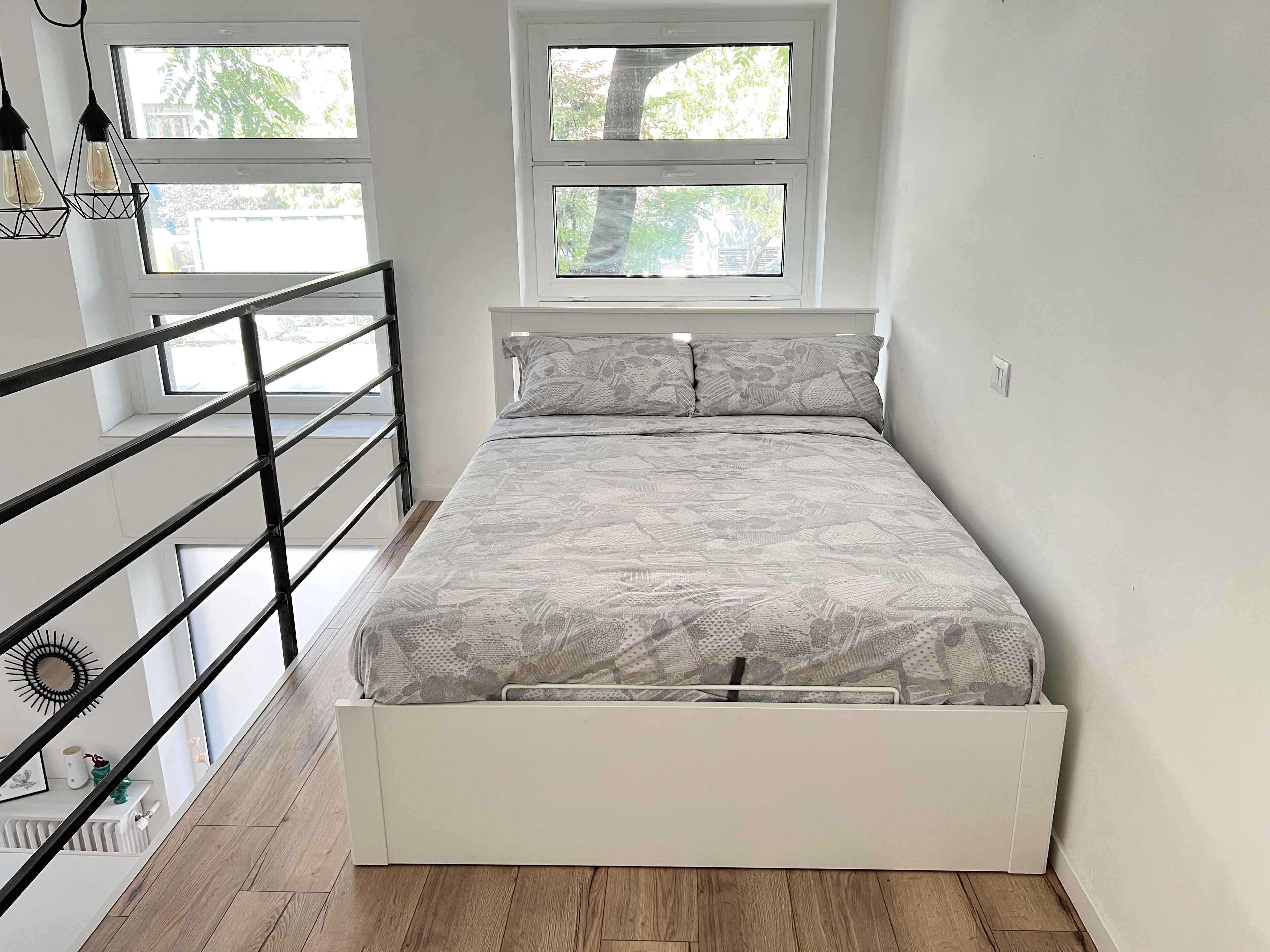 Une chambre à coucher avec un lit, une fenêtre et un escalier.