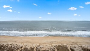 Una playa con cielo despejado y mar en calma.