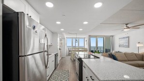 Una cocina moderna con un refrigerador de acero inoxidable, una isla central y vistas al exterior.