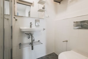 A bathroom with a white sink, mirror, and a towel rack.