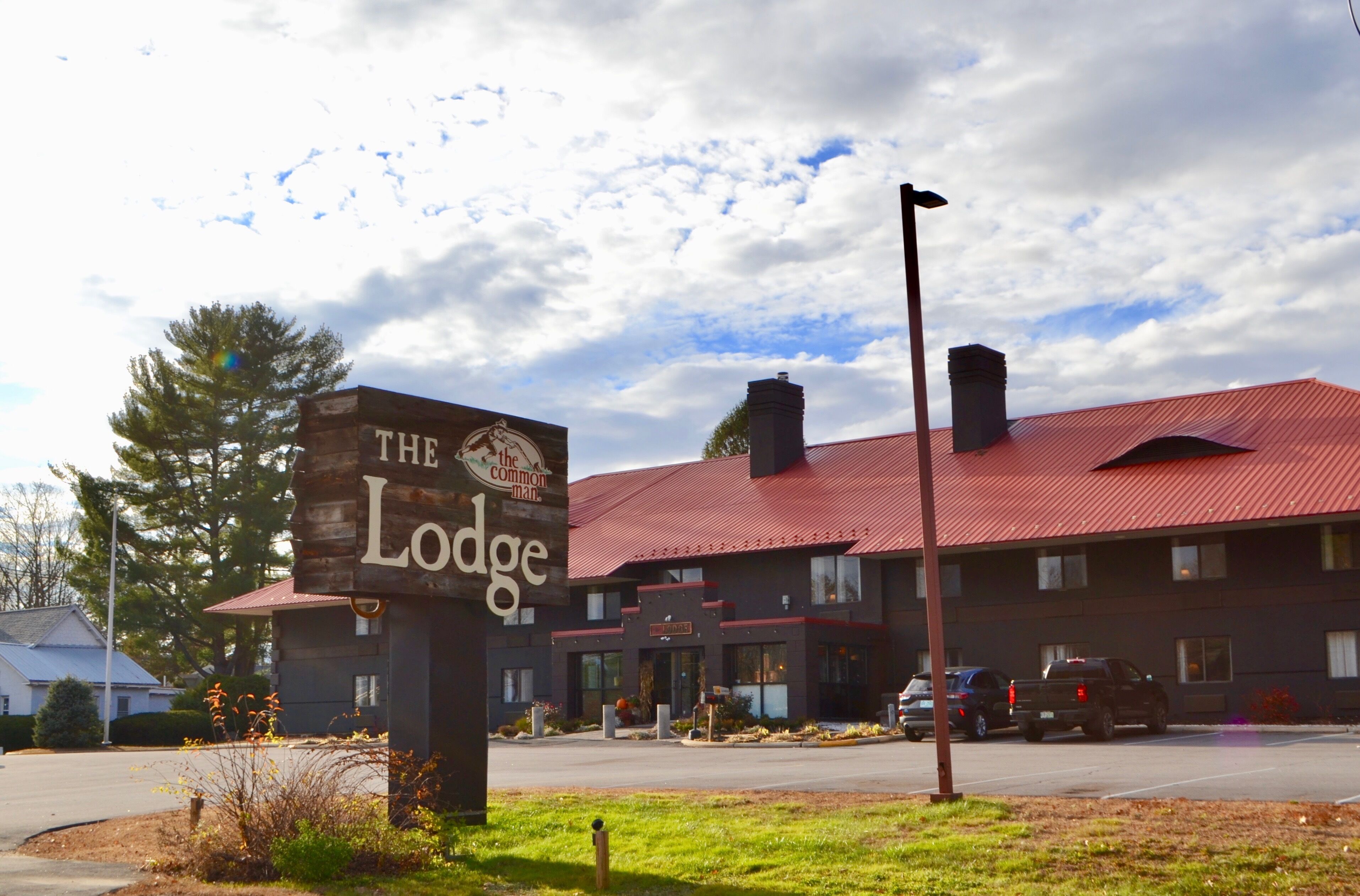 A building with a red roof and a sign that reads "The Lodge."
