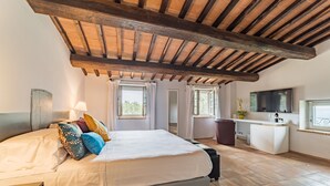 Un dormitorio con cama, escritorio, televisión y ventana.