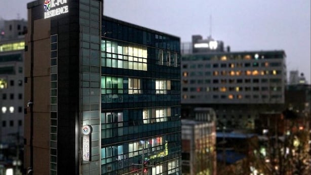 A modern building with a sign reading "K-Pop Residence." - Hostel Kpop (Seoul)