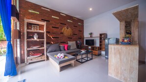 Un salon moderne avec un canapé, un téléviseur et un meuble en bois.