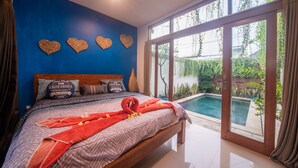 Une chambre avec un grand lit, une vue sur une piscine et des décorations murales en forme de cœur.