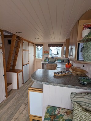 A compact kitchen with wooden cabinets, a granite countertop, and a built-in sink.