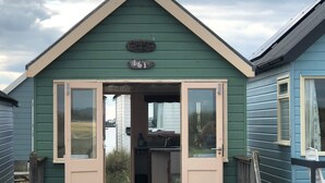 A small, green building with a sign reading "CRACKERJACK." It has a door open to a kitchen area with a window and a door.