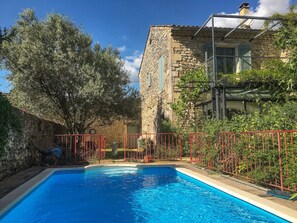 A swimming pool with a stone building and a tree in the background. - Village house with private pool, Grignan   – Drôme Provençale (Grignan)