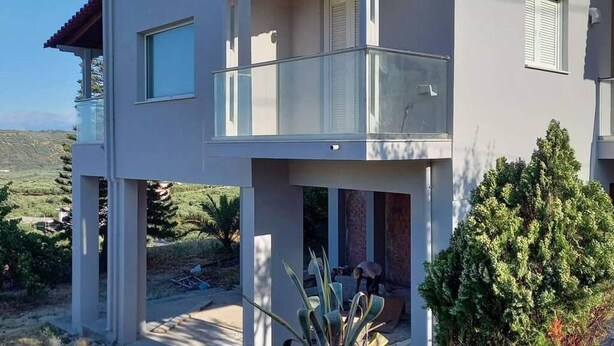 A two-story modern house with a balcony, a clear sky, and a mountainous landscape in the background. - Beautiful 3-bed House in Chania With Garden (Platanias)