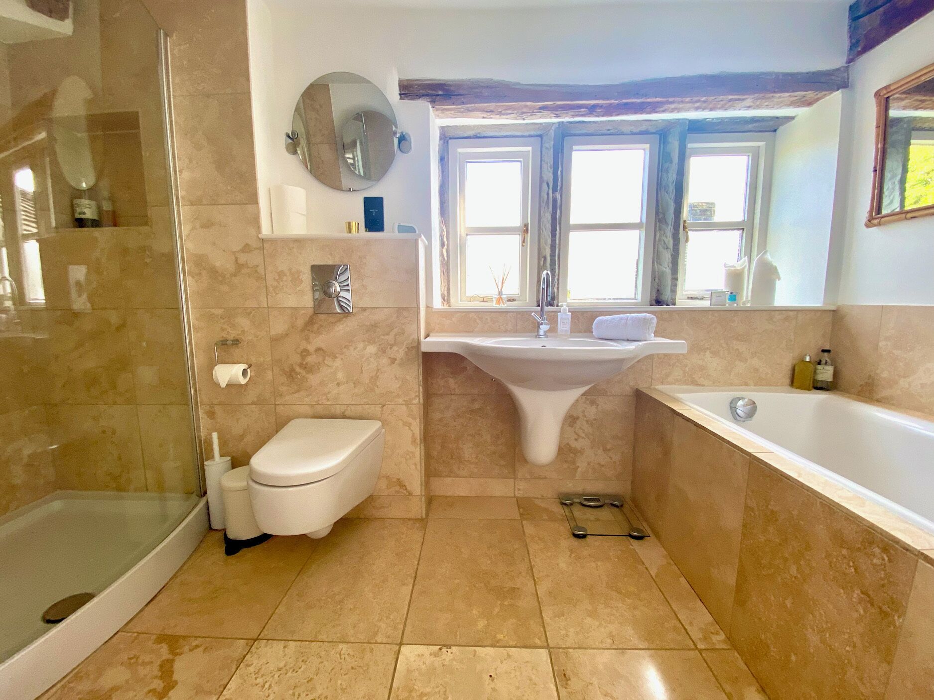 A bathroom with a glass shower enclosure, a toilet, a sink, and a bathtub.