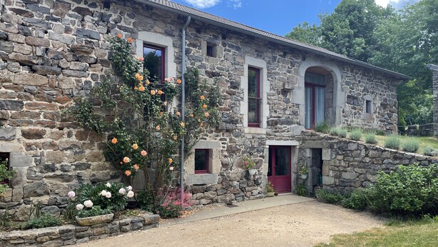 A stone building with a gravel driveway and a garden with flowers. - Superb 450 m2 farmhouse fully restored in Haute Loire (Araules)