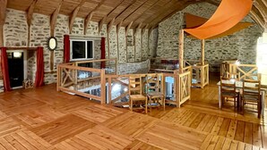 A rustic interior with a high wooden ceiling, stone walls, and a wooden boat structure. - Superb 450 m2 farmhouse fully restored in Haute Loire (Araules)
