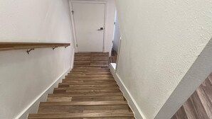 A staircase with wooden steps and white walls. - Casa Wooten -Contemporary Condo (Austin)