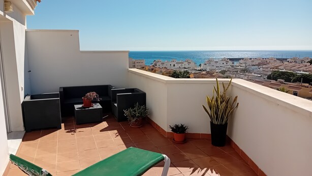 Un balcon avec vue sur la mer et sur le paysage urbain.