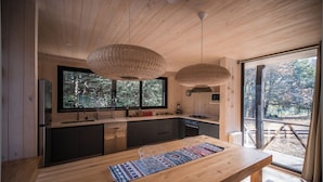 Une cuisine moderne avec des meubles en bois, un grand îlot central et une vue sur l’extérieur.