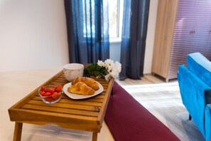 Une table en bois avec des croissants, des fraises et une tasse.