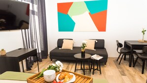 A modern living room with a sofa, coffee table, and dining area. - City Life Rijeka (Rijeka)
